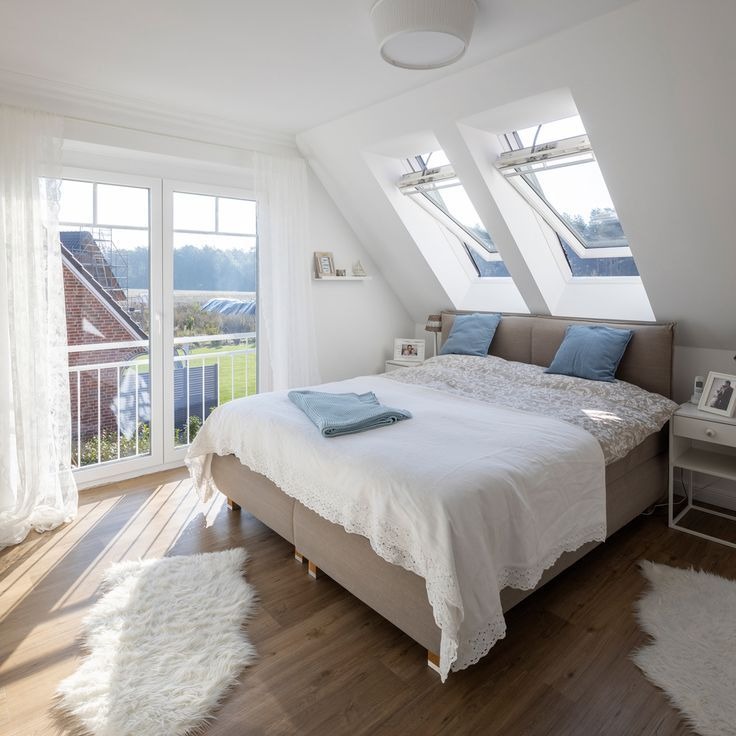 Bright attic bedroom with skylight windows and balcony door