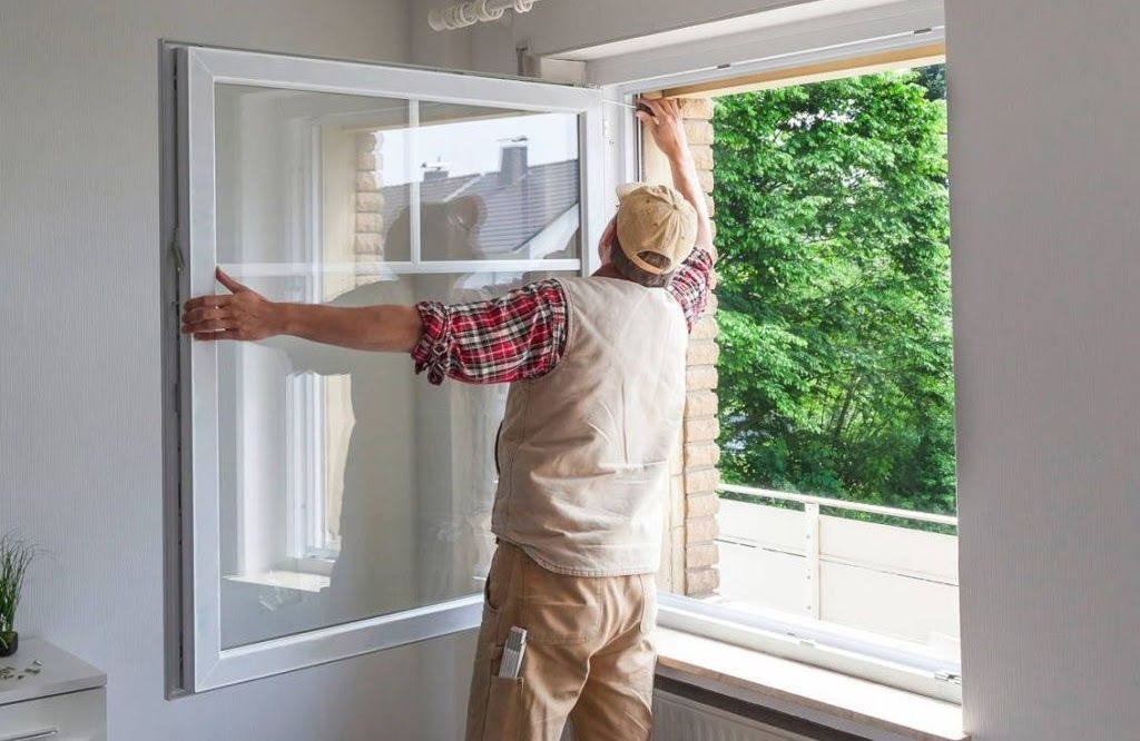 Professional installer replacing energy-efficient vinyl window at home