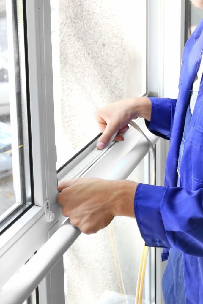 Technician installing window seal to prevent air leakage