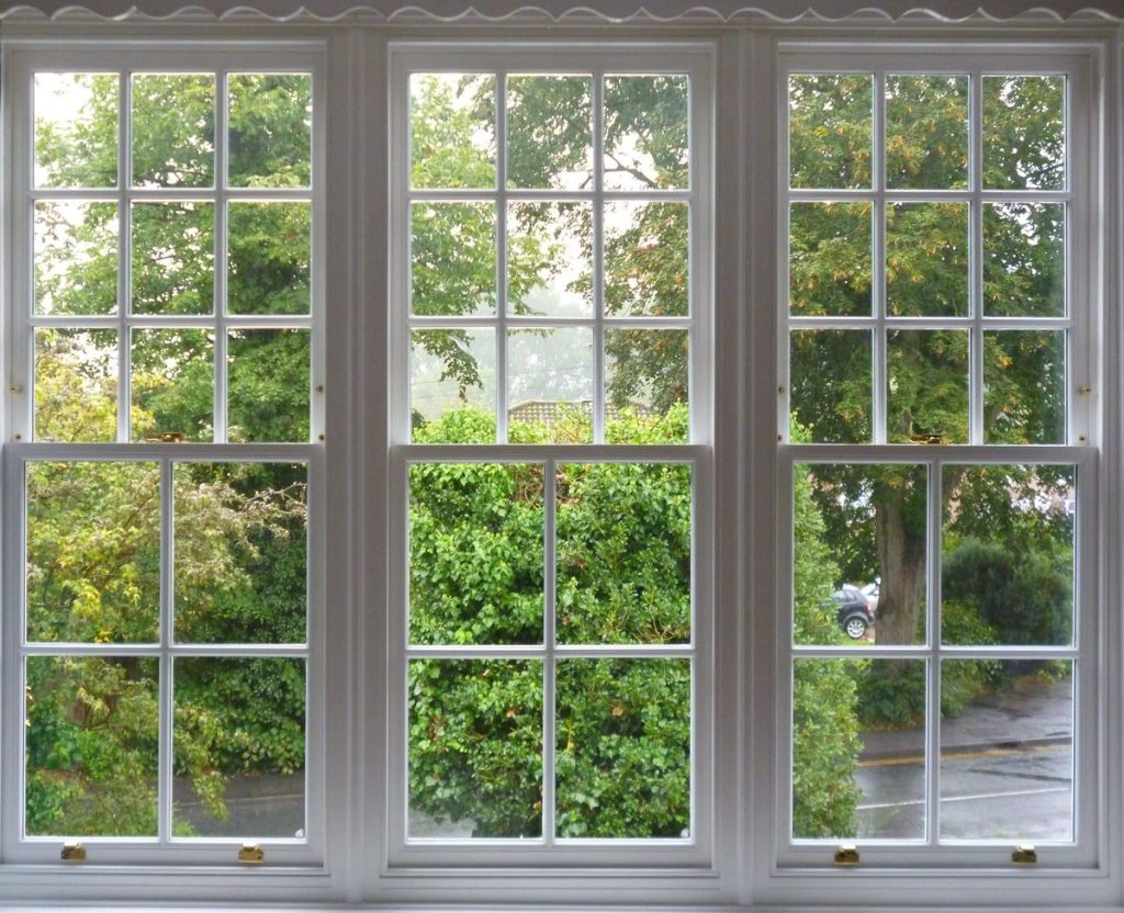 Traditional sash windows with white wooden frames and grilles